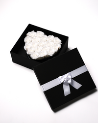 Eighteen white preserved roses in a black heart-shaped box