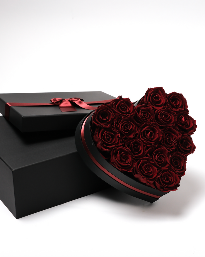 Eighteen burgundy preserved roses in a black heart-shaped box
