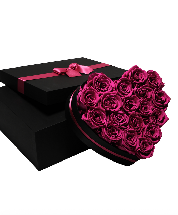 Eighteen hot pink preserved roses in a black heart-shaped box