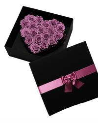 Eighteen lilac preserved roses in a black heart-shaped box