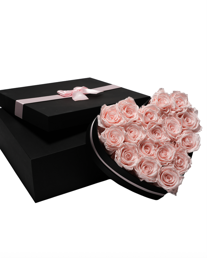 Eighteen pale pink preserved roses in a black heart-shaped box