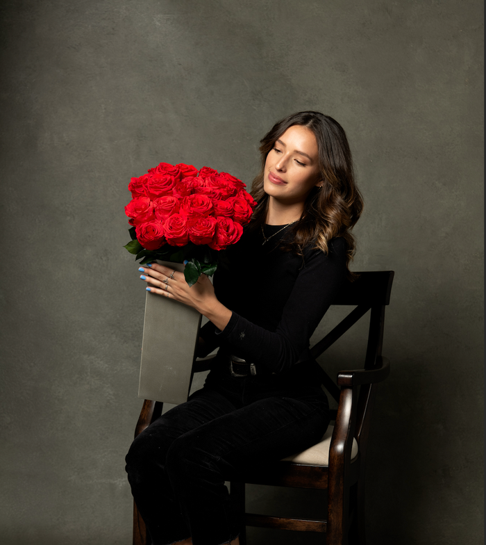 Woman holding a bunch of long-stem red preserved roses